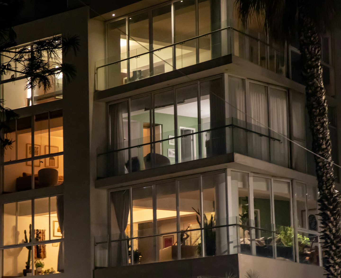 Modern apartment building at night with warm lit interiors.